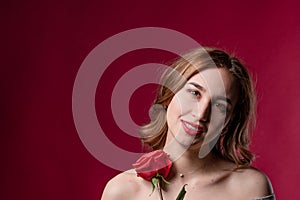 Portrait of a beautiful girl with bare shoulders and a rose. The concept of youth, beauty and a healthy body