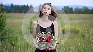 Portrait of a beautiful girl with a basket of flowers in their hands.