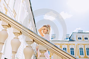 Portrait of beautiful girl in the beautiful palace in summer.  Pretty young woman with pink dress on holiday