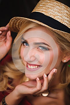 Portrait of a beautiful girl with blond hair. Stylish girl is sitting on a park bench. Fashion model.