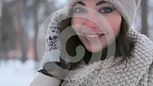 Portrait of a beautiful girl with blue eyes posing in a winter park in a good mood. close-up