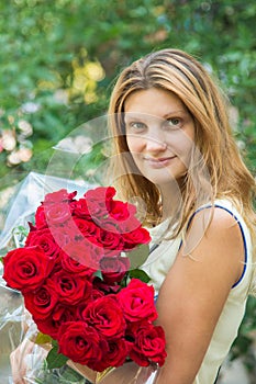 Portrait of a beautiful girl with a bouquet of roses in her hands