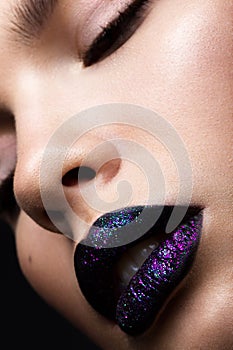 Portrait of a beautiful girl. Brilliant glossy lips closeup. Purple glitter on black lipstick