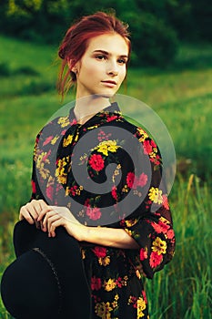 portrait of a beautiful girl with brown hair among the flowers in the field. summer holiday with flowers. countryside