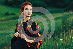 portrait of a beautiful girl with brown hair among the flowers in the field. summer holiday with flowers. countryside