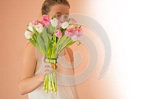 Portrait of a beautiful girl in dress holding tulip bouquet