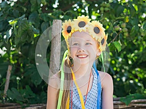 Portrait of beautiful girl with flowers of sunflowers on his head.