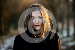 Portrait of a beautiful girl with flying hair in the wind. Young sad woman. Portrait of lonely woman