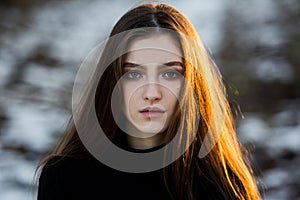Portrait of a beautiful girl with flying hair in the wind. Young sad woman. Portrait of lonely woman