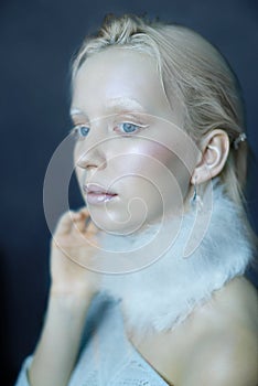 Portrait of a beautiful girl in the frost on his face on a blue ice background