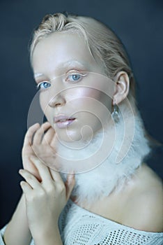 Portrait of a beautiful girl in the frost on his face on a blue ice background