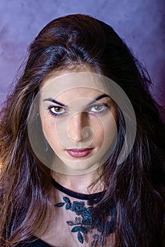 Portrait of a beautiful girl on a gray background, in a black dress with a serious look with perfect makeup isolated on black back