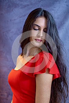 Portrait of a beautiful girl on a gray background, in a black dress with a serious look with perfect makeup isolated on black back