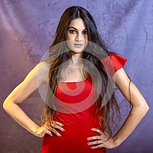 Portrait of a beautiful girl on a gray background, in a black dress with a serious look with perfect makeup isolated on black back