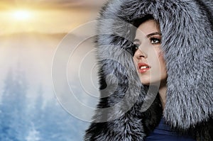 Portrait of a beautiful girl in a gray fur hat on a background o