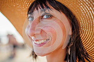Portrait of a beautiful girl in a hat. young woman smiling on the beach - Charming girl enjoying a sunny day - Healthy lifestyle