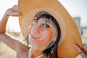 Portrait of a beautiful girl in a hat. young woman smiling on the beach - Charming girl enjoying a sunny day - Healthy lifestyle