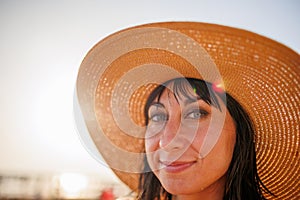 Portrait of a beautiful girl in a hat. young woman smiling on the beach - Charming girl enjoying a sunny day - Healthy lifestyle