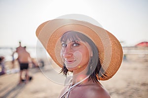 Portrait of a beautiful girl in a hat. young woman smiling on the beach - Charming girl enjoying a sunny day - Healthy lifestyle