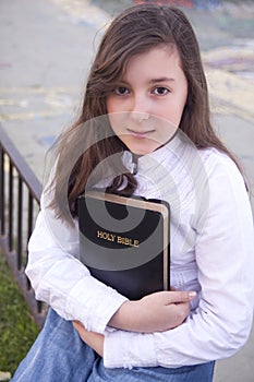 Portrait of beautiful girl holding bible