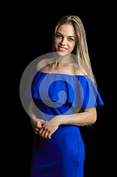 Portrait of a beautiful girl with light retouching skin. Studio portrait on a isolated black background. Blonde in blue