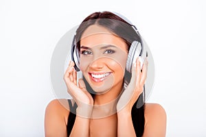 Portrait of beautiful girl listening music in white headphones
