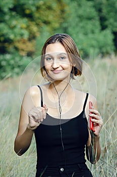 Portrait of a beautiful girl listening to music with headphones on the street