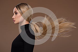 Portrait of beautiful girl with long airy hair. Brown background photo