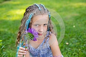 Portrait of beautiful girl with many braids with blue kanekalon on nature background.Smiling beautiful caucasian girl