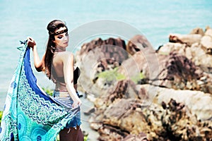 Portrait of beautiful girl by the ocean with blue scarf