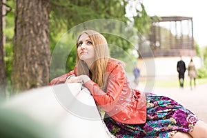 Portrait of a beautiful girl on a park bench