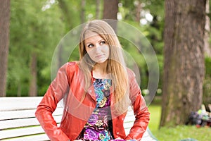 Portrait of a beautiful girl on a park bench