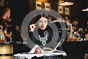 Portrait of a beautiful girl reading book in cafe