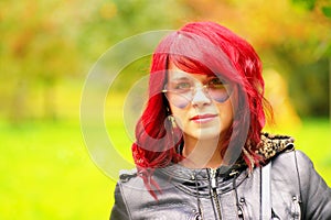 Portrait of a beautiful girl with red hair and heart like glassess