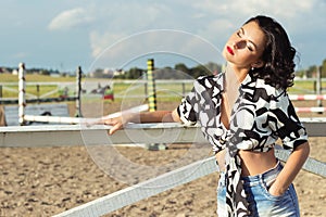 Portrait of a beautiful girl with red lips brunette with curls walks in the Park