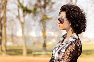 Portrait of a beautiful girl with red lips brunette with curls walks in the Park