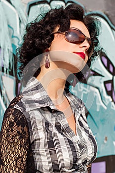 Portrait of a beautiful girl with red lips brunette with curls walks in the Park