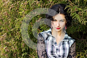 Portrait of a beautiful girl with red lips brunette with curls walks in the Park