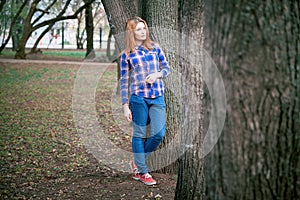 Portrait of a beautiful girl. smiling, posing on camera. in a blue shirt in a cage. Against the background of the autumn