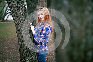 Portrait of a beautiful girl. smiling, posing on camera. in a blue shirt in a cage. Against the background of the autumn