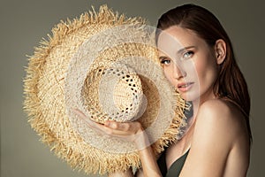 Portrait of beautiful girl with a straw hat in her hands