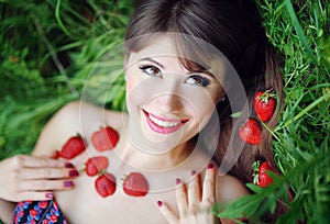 Portrait of a beautiful girl with strawberries in the park