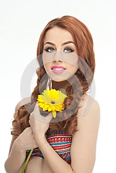 Portrait of beautiful girl in studio with yellow chrysanthemum in her hands. young woman with blue eyes with bright flower