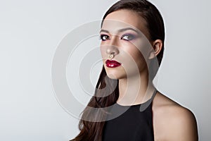 Portrait of a beautiful girl with a sweet delicate burgundy lips and bright makeup in a light transparent negligee studio on a whi