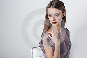 Portrait of a beautiful girl with a sweet delicate burgundy lips and bright makeup in a light transparent negligee studio on a whi