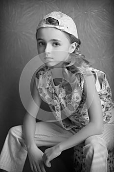 Portrait of beautiful girl in t-shirt and trousers in the inverted cap room beforehand black and white photography