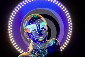 Portrait of beautiful girl with ultraviolet paint on her face