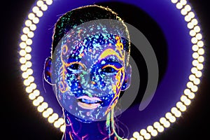 Portrait of beautiful girl with ultraviolet paint on her face