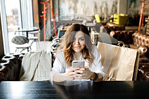 Portrait of beautiful girl using her mobile phone in cafe