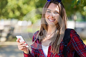 Portrait of beautiful girl using her mobile phone in city.